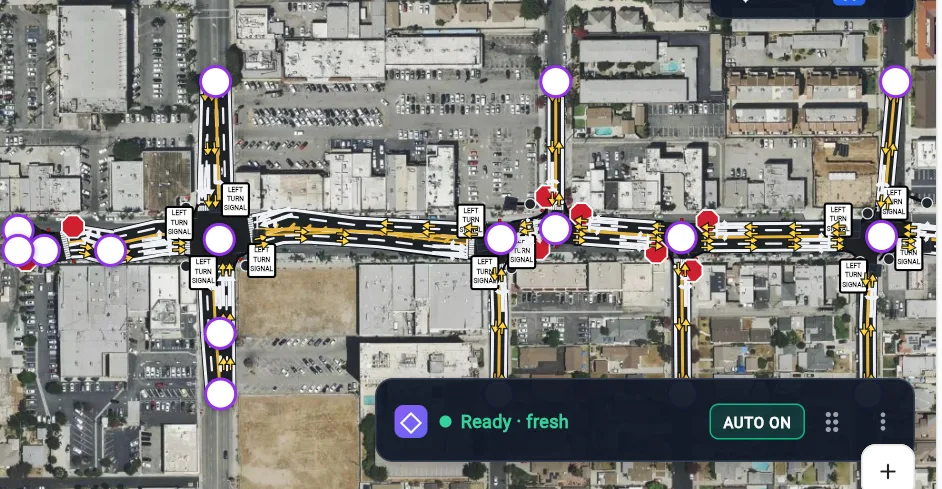 AI Build output: a signalized corridor with lane lines, turn arrows and signal heads over satellite imagery